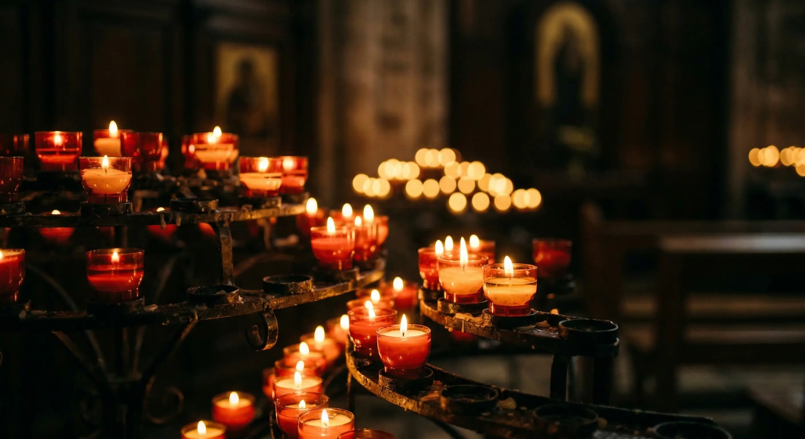 Rows of glowing votive candles in a dim church, each flame a silent prayer